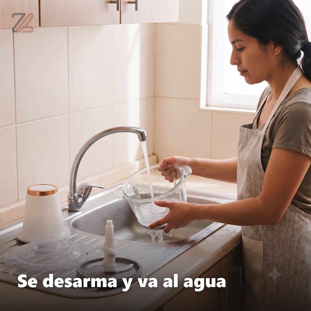 Mujer lavando el vaso de vidrio de la picadora desarmada en el lavaplatos